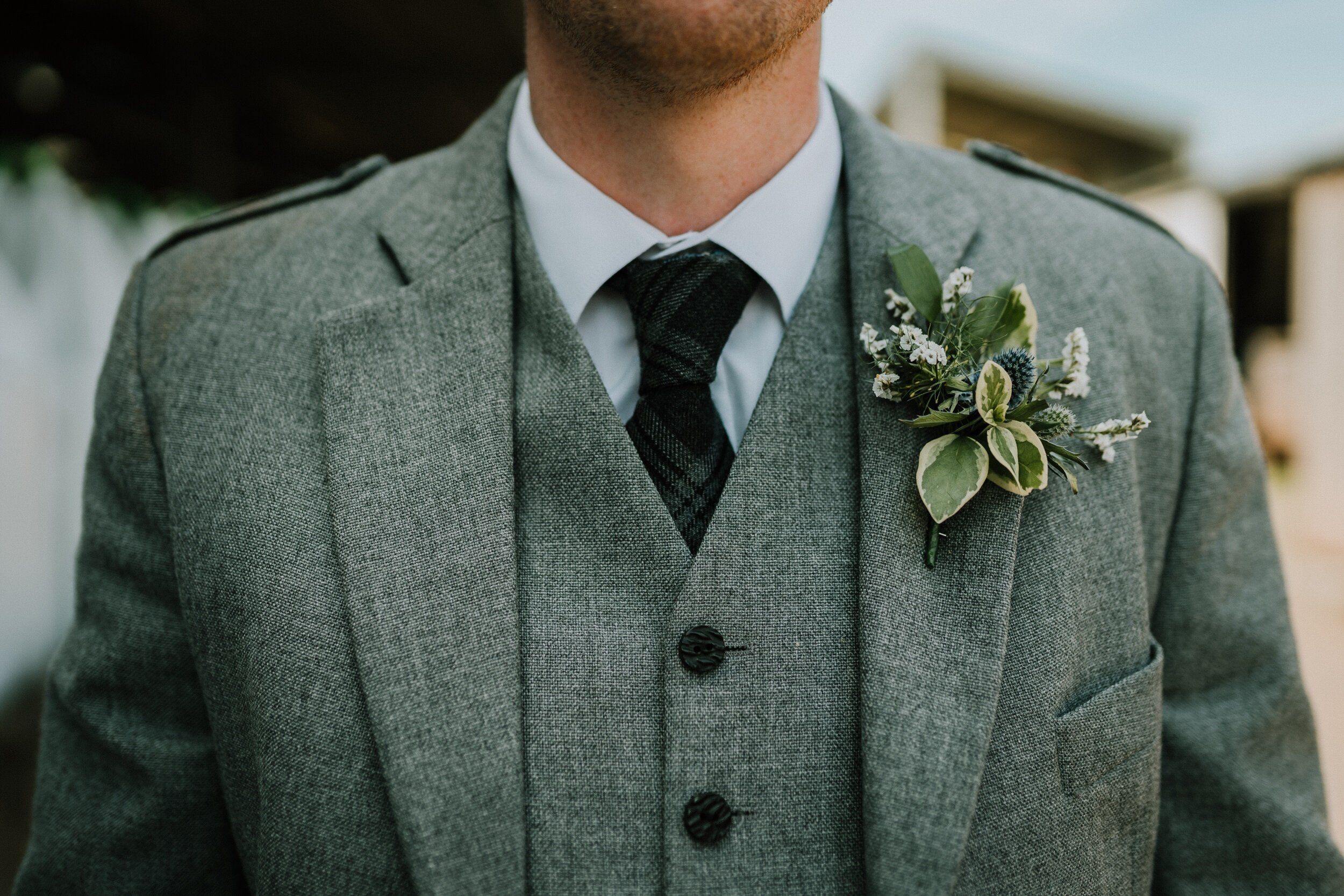 Groom in grey kilt jacket and waistcoat with beautiful button hole at perthshire weddingh