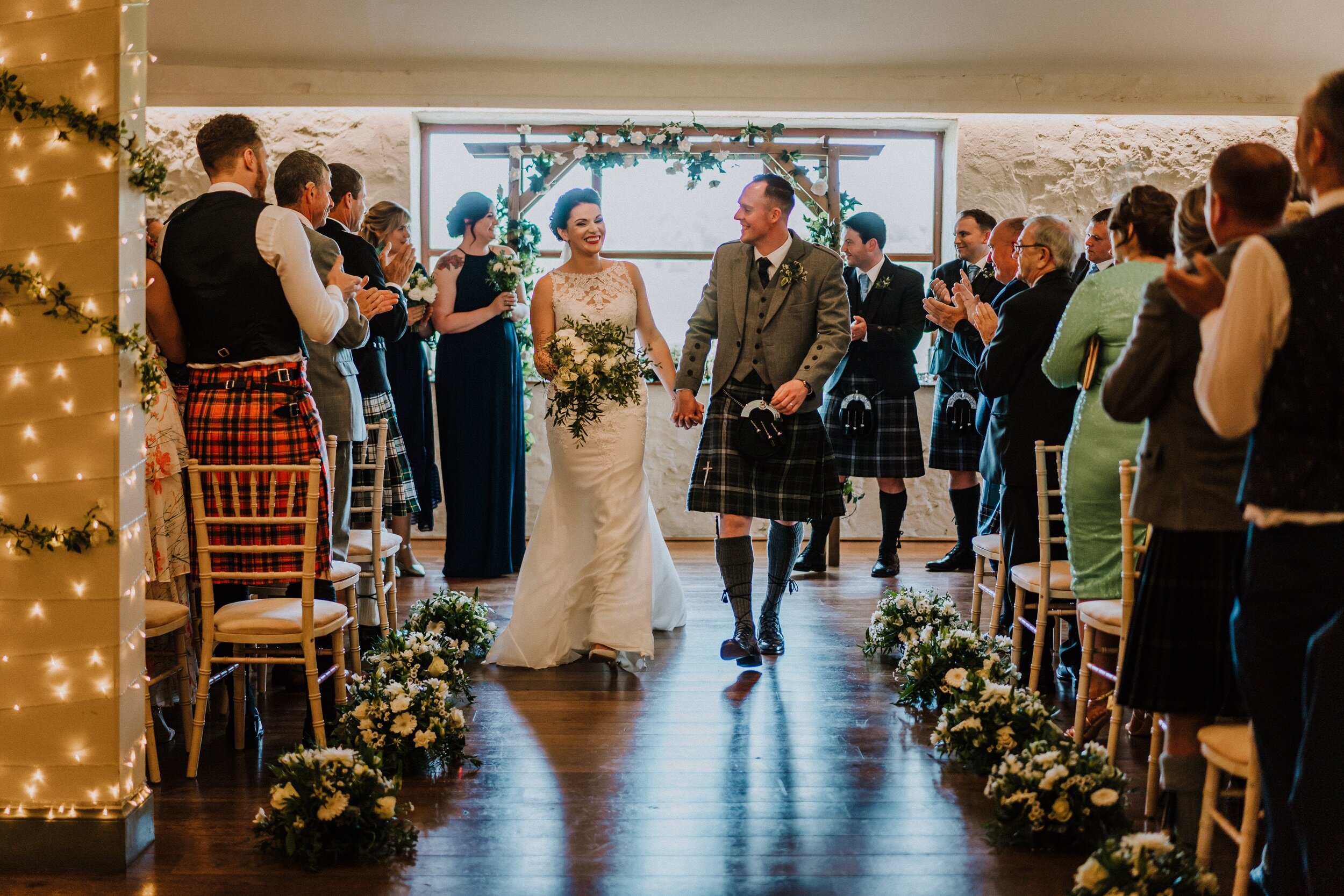 Scottish newlyweds coming down aisle at Bachilton Barn