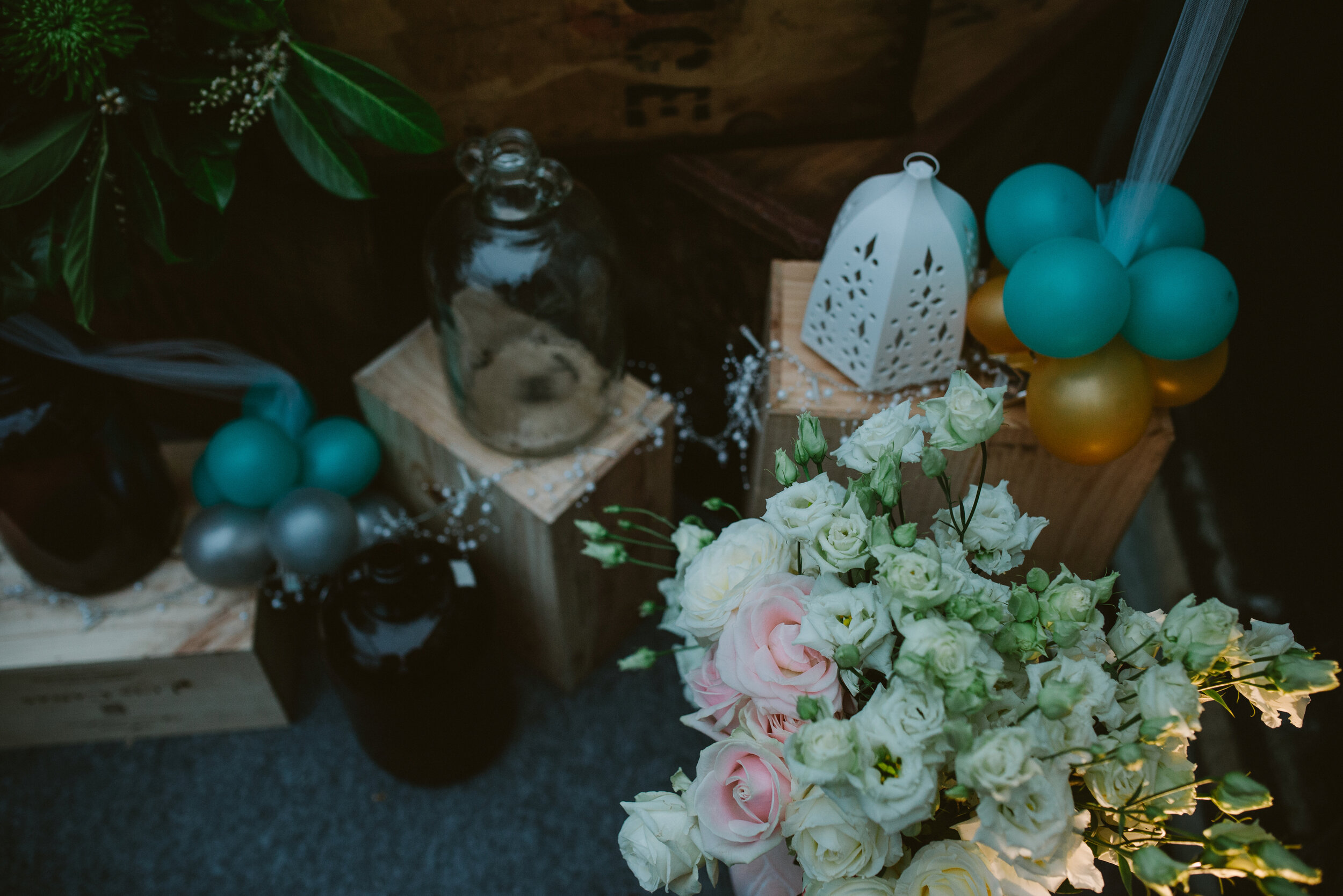 Floral arrangements surrounded by blue balloons and crates 