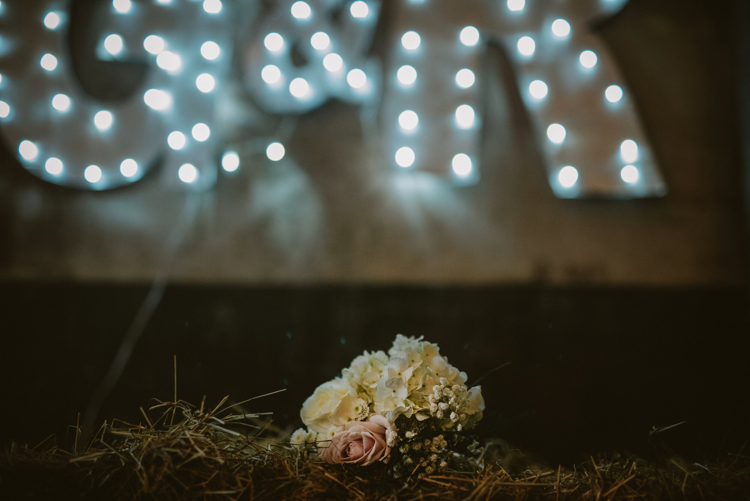 White bridal bouquet in front of illuminated G & K