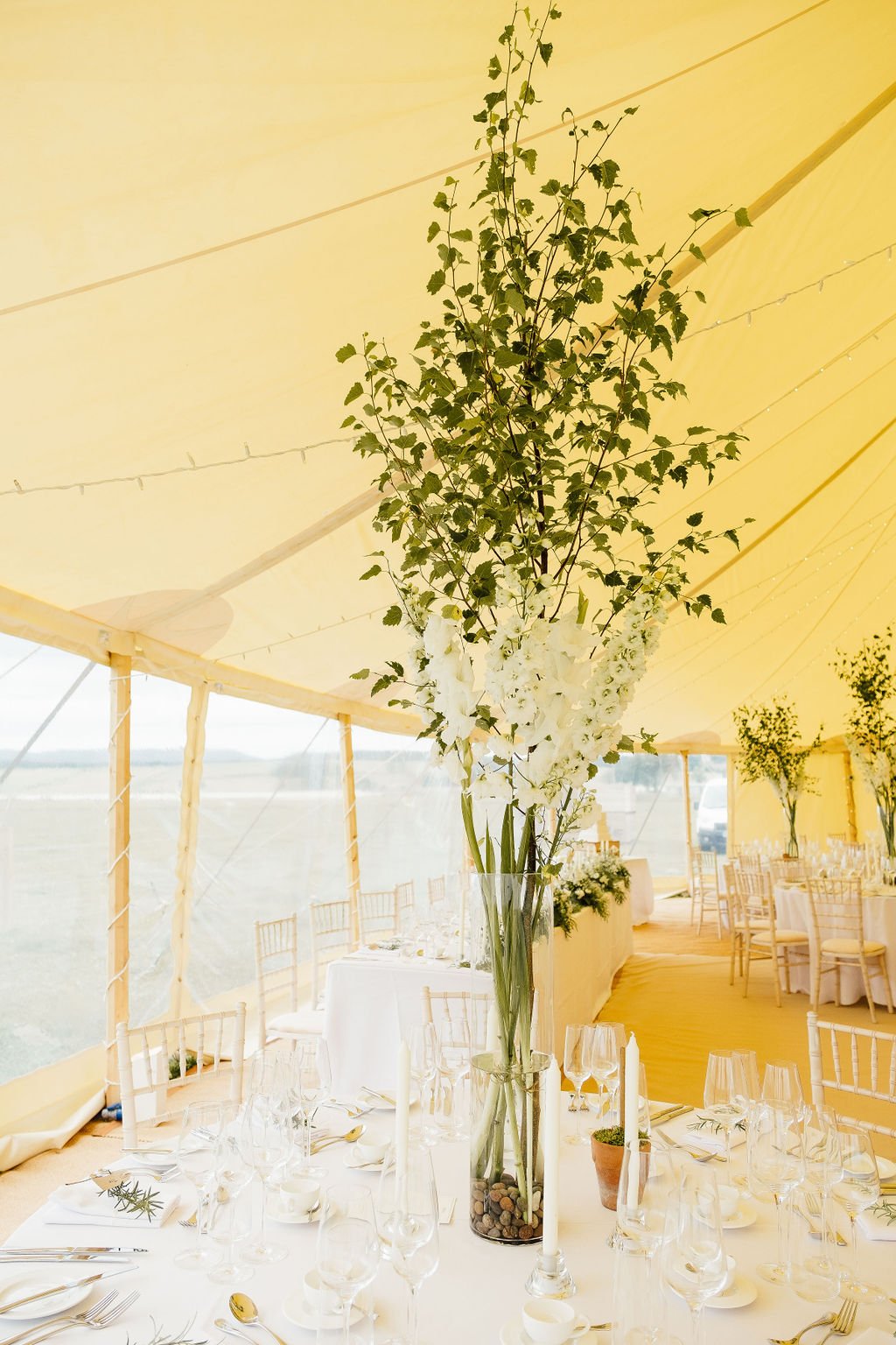 Tall vase filled with fresh green foliage at Scottish wedding 