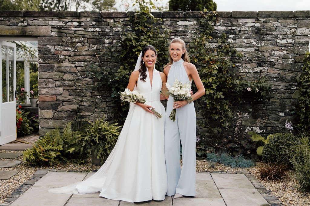Bride and bridesmaid standing together at Scottish country wedding 