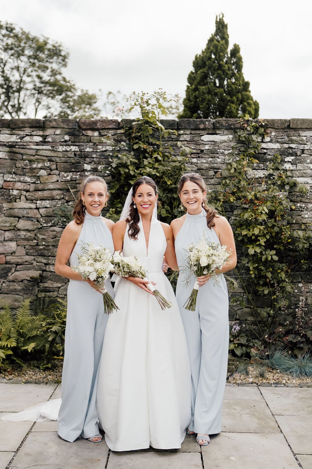 Scottish Bride standing with bridesmaid either side holding white bouquets