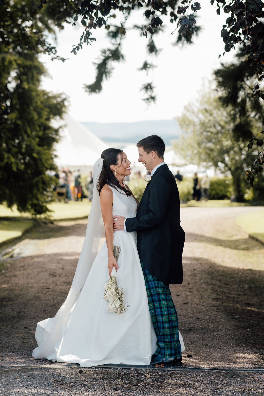 Bride and groom portrait standing outside summer wedding marquee