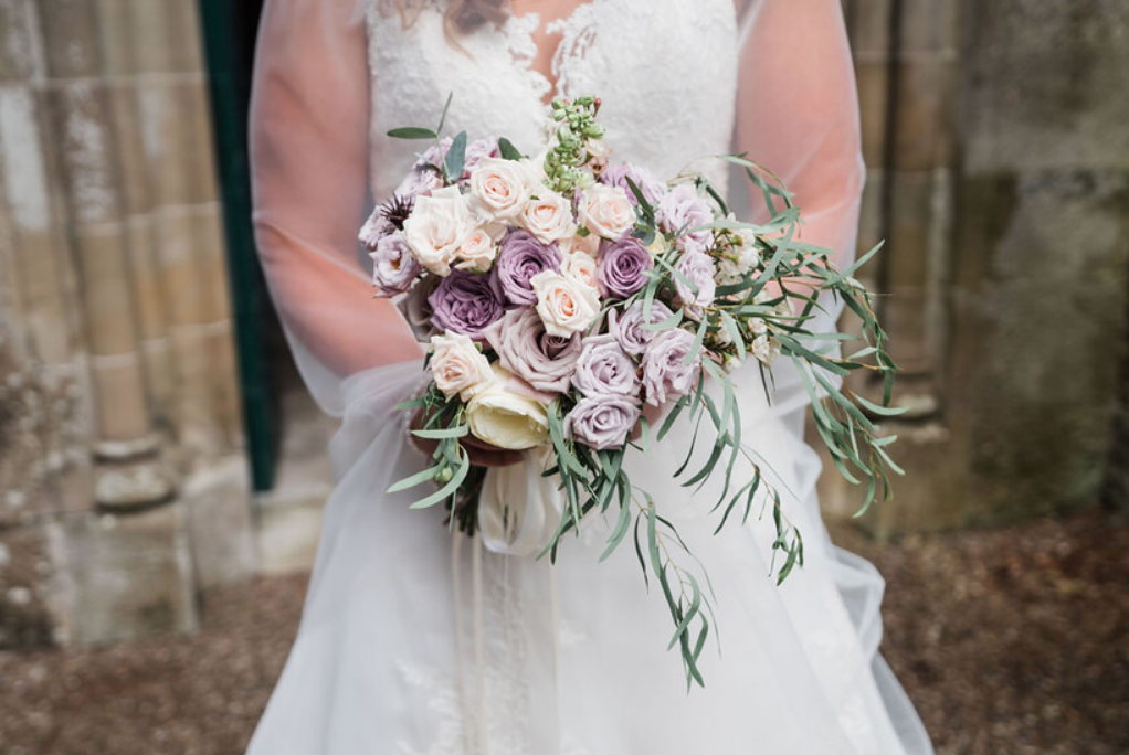 Loose, unstructured bridal bouquet filled with lilac and cream roses