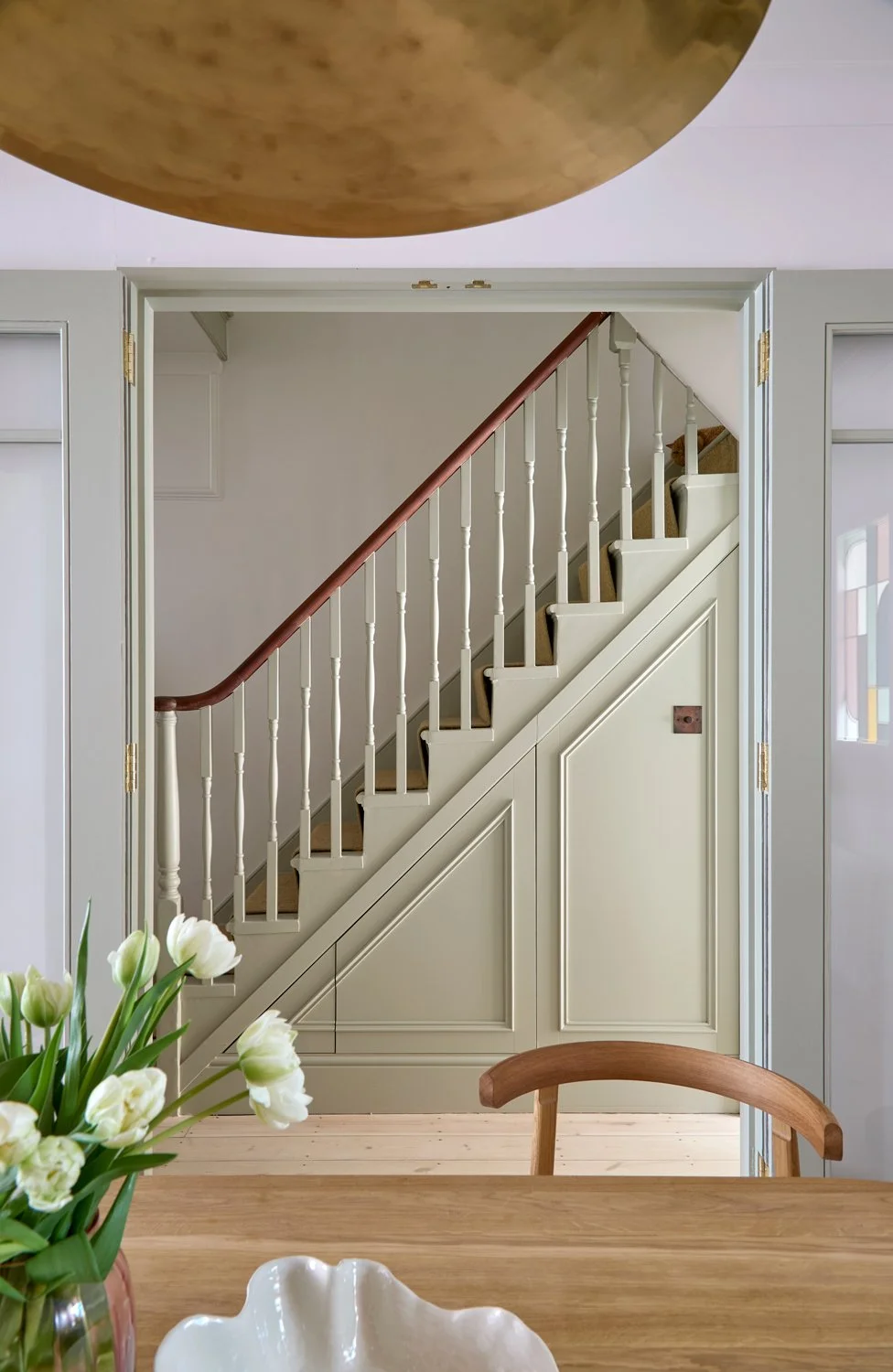  The new glazed double-door opening between the hallway and dining area redefines the flow of the ground floor, drawing natural light deep into the space. An existing doorway between the kitchen and dining room was reinterpreted as a bespoke multi-co