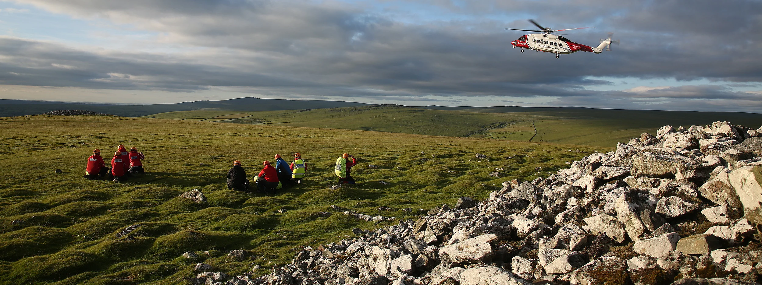 Volunteer rescuers moving across open Dartmoor