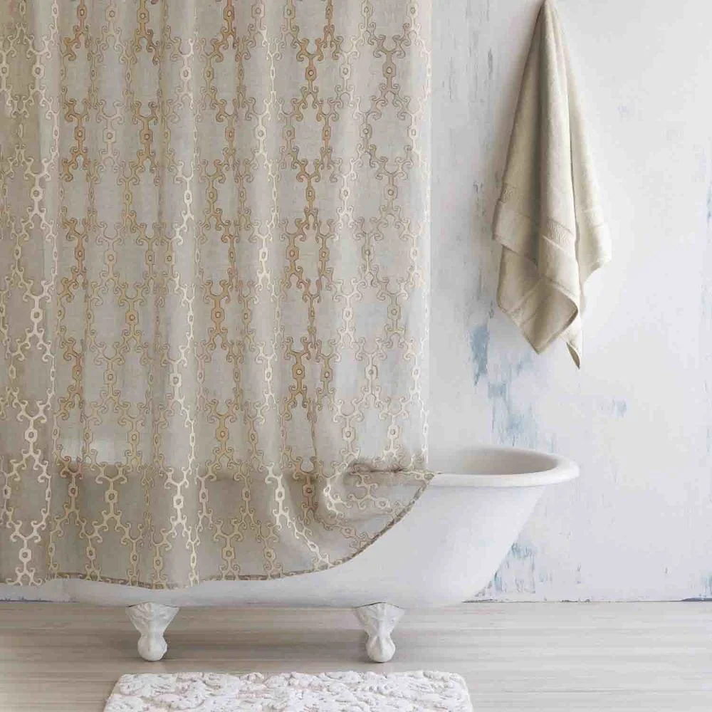 Beige pattern shower curtain and white rug