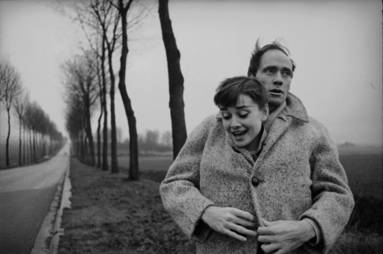 American actor Mel Ferrer (1917 - 2008) buttons up his coat around his wife, actress Audrey Hepburn (1929-1993), on a country road outside Paris, 1956. (Photo by Ed Feingersh/Michael Ochs Archives/Getty Images)