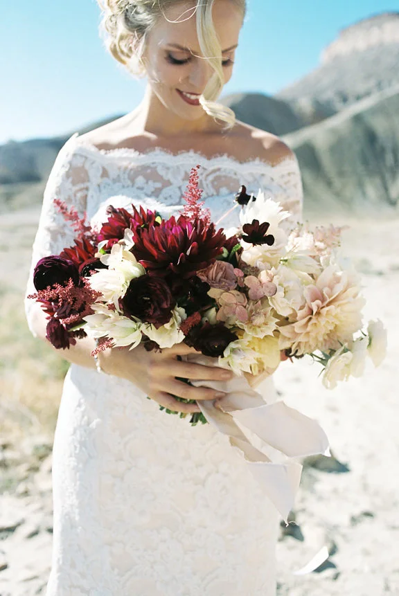  A desert wedding bouquet of dahlias, astilbe, chocolate cosmos, lace cap hydrangea, ranunculus, garden roses, and blushing bride Photo by Kaylan Robinson