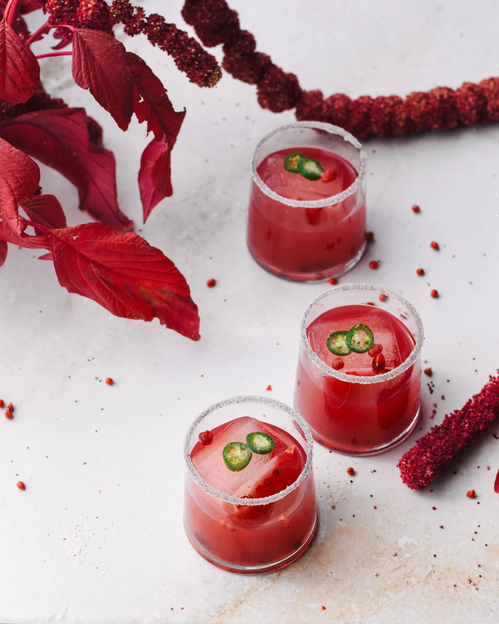 A cocktail that captures the glow of the season. 🥂 This spicy pomegranate margarita is winter ritual in a glass &mdash; bright, warming and just smoky enough to linger. Blending pomegranate juice, fresh citrus, serrano heat and a kiss of mezcal, thi