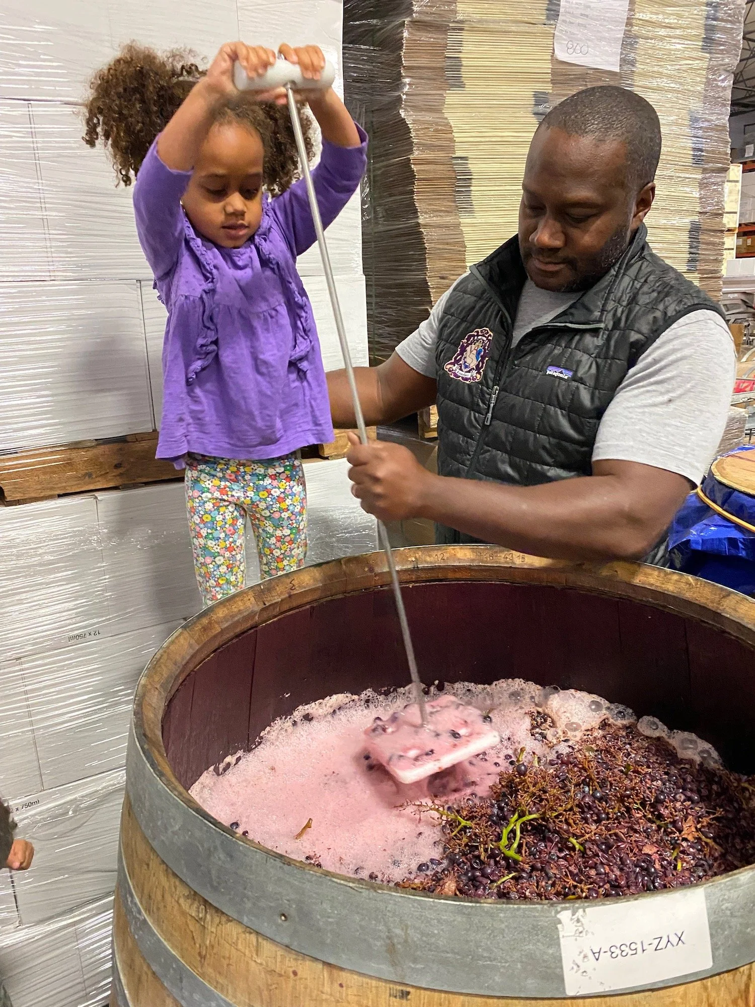 Johnson punches down fermenting syrah grapes with his daughter, Sicily