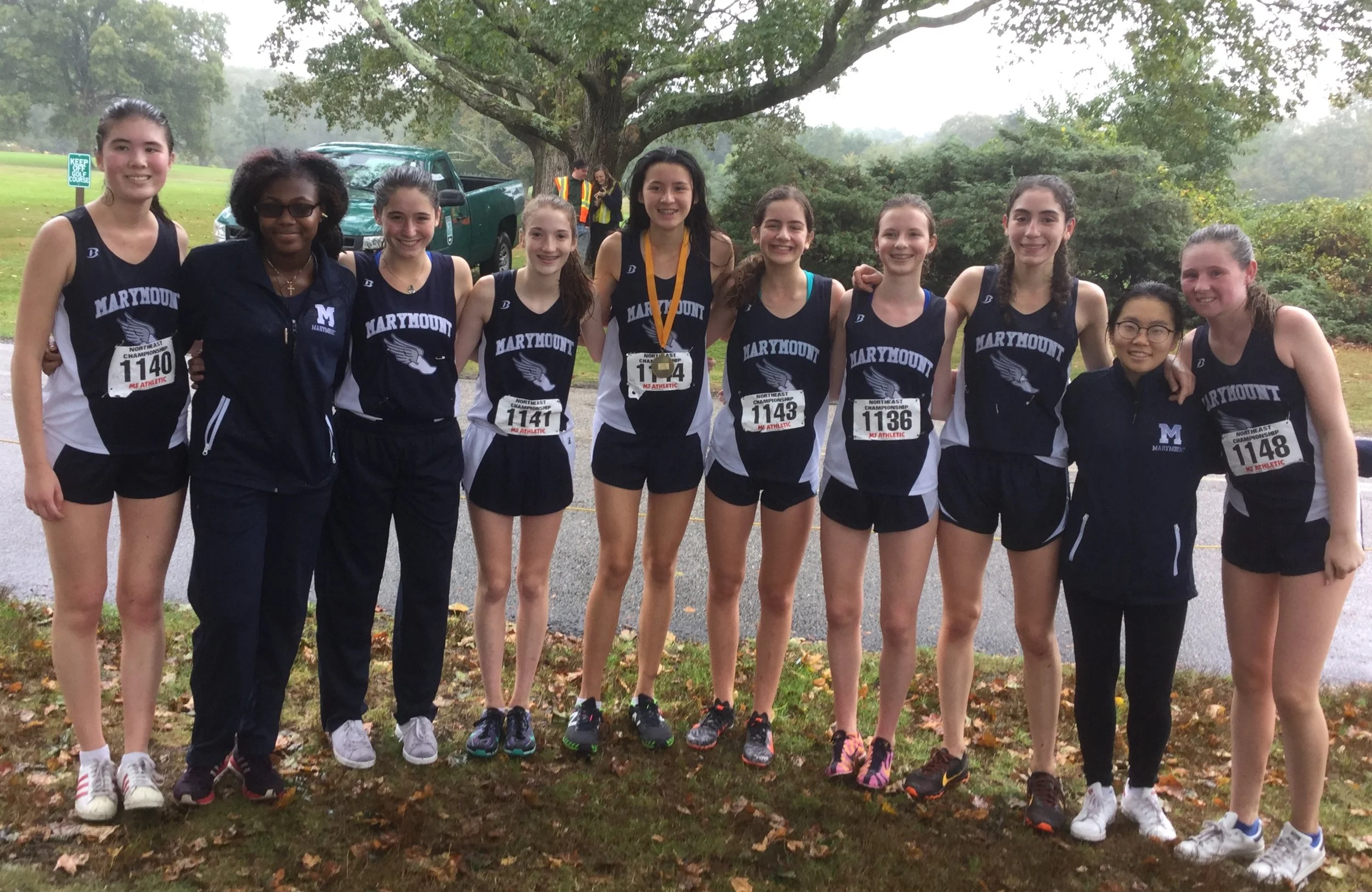 Varsity Cross Country members pose for a picture after one of their races.