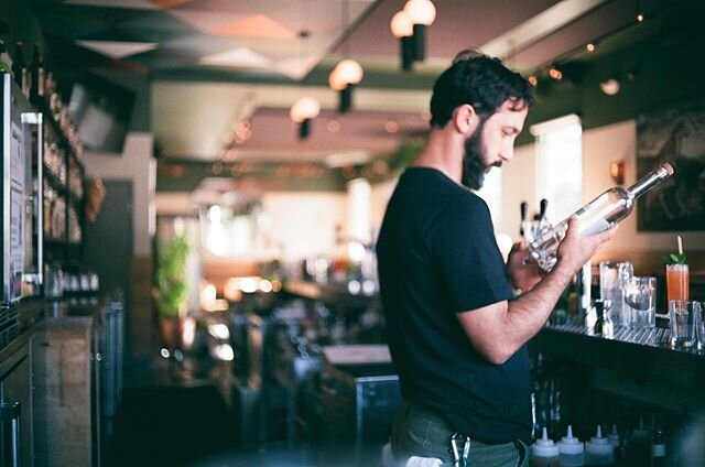 🎞 lil film capture by our neighbor and friend @nombre_kj &bull; @koochymonster in caught in some deep thought 💭 checking the production specs on some amazing @netaspirits mezcal (or maybe just pretending to read?)