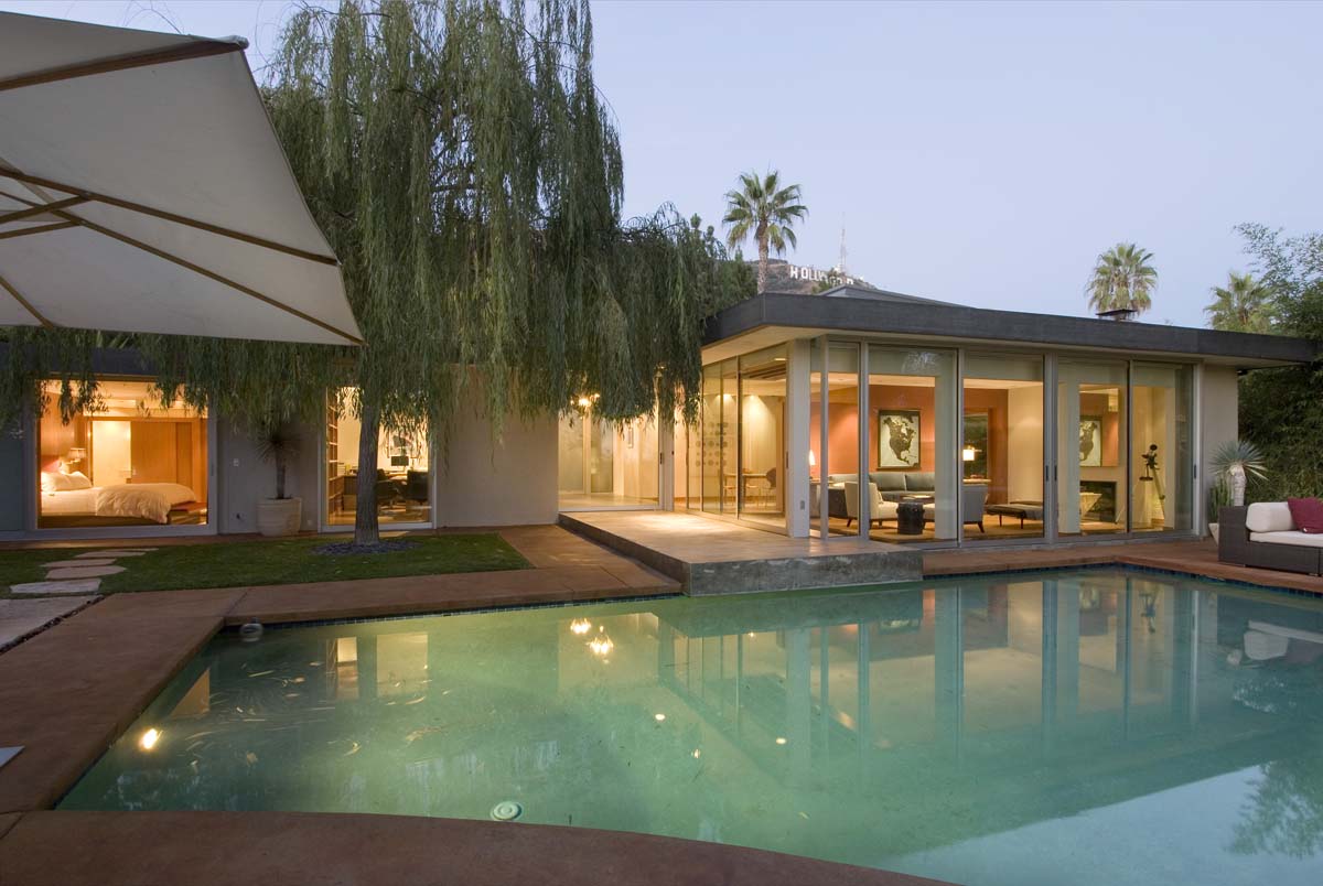This modest mid-century home in Hollywood had good bones but was in need of a renovation. In both practical and poetic terms, the house also required a new attitude towards the charming backyard and spectacular views of Lake Hollywood and the Hollywood sign. The new layout is an open, informal arrangement of rooms. Everything was simplified, clarified, refined. Unnecessary door frames, moldings, and little hallways were eliminated so that space now floats around corners. Lines of sight were extended to the outside, and full-height windows and doors and skylights were added to further unite the interior and the exterior. In the process, a small, dark house became a light-filled gem. The remodeled home is contemporary, while retaining a strong connection to the earth.