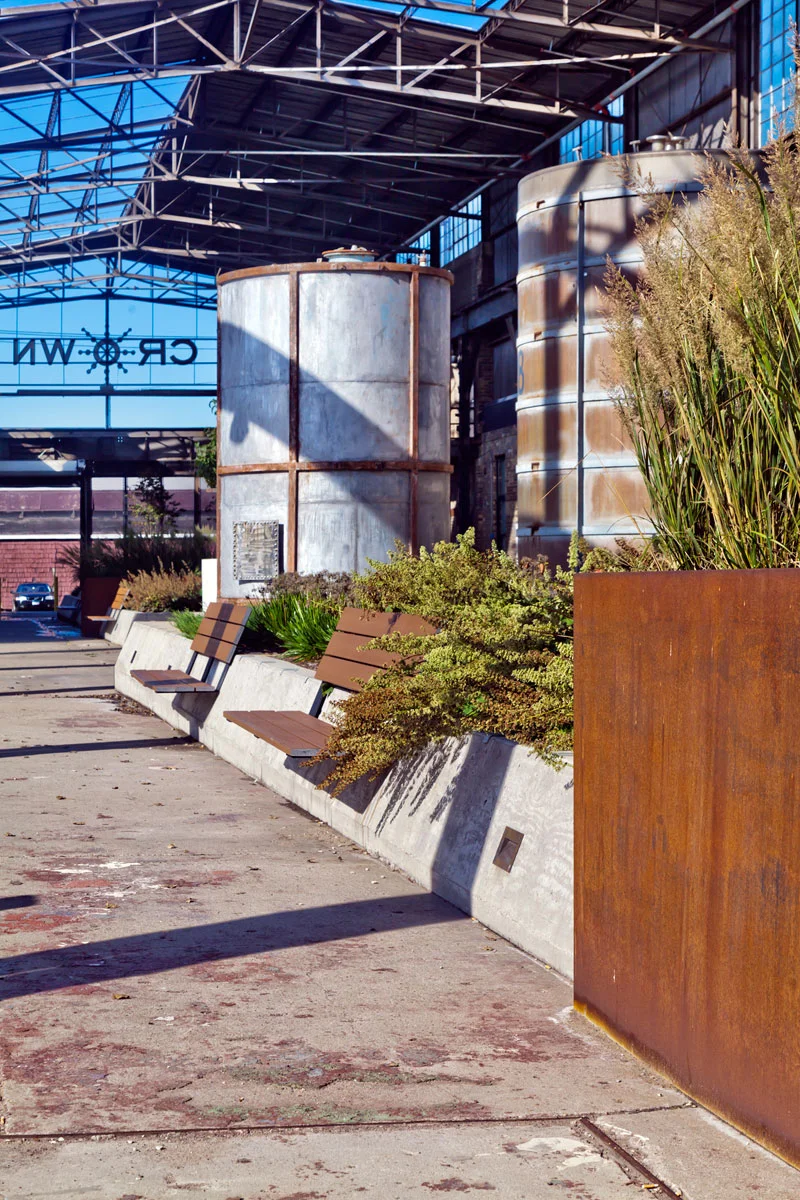 Simple, resilient plantings provide a contrast to the industrial surroundings giving the monumental space a humanizing touch.