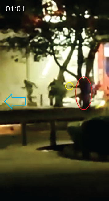  The officer points the object, a handgun, offscreen to the left, in the direction in which civilians have fled. 