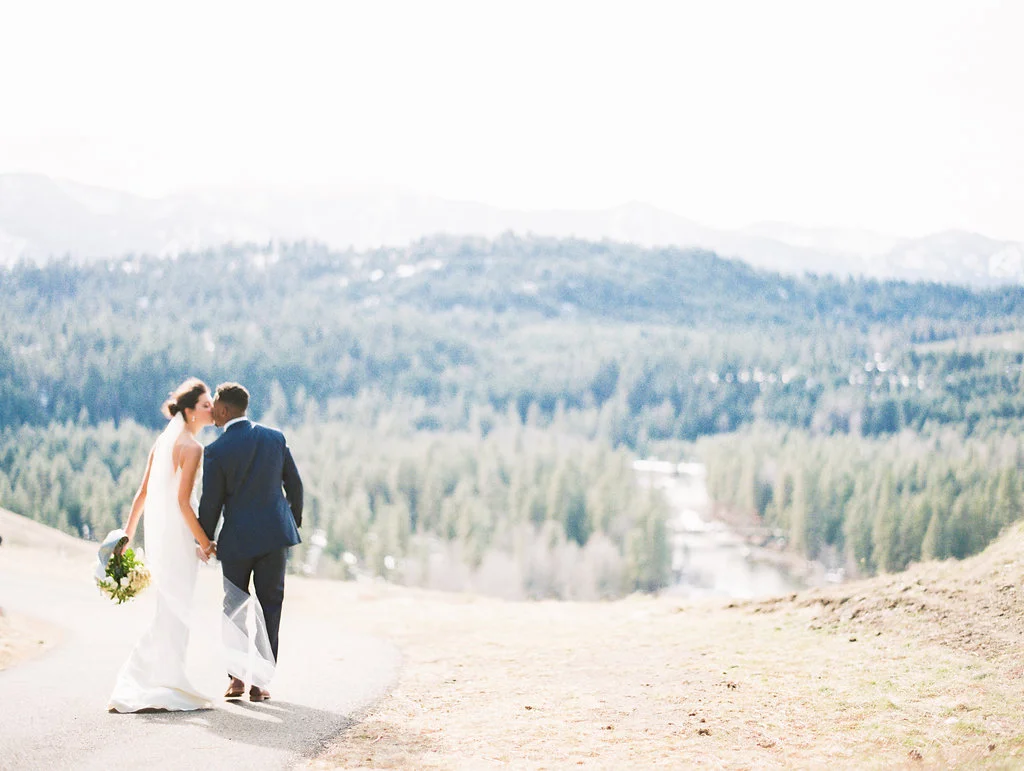 Rian & D'Andre were married in the mountains just east of Seattle. It was a crystal clear, blue sky day after a week of rain and snow. The tables were overflowing with eucalyptus, large white peonies, and cascading branches of blooming pieris. The aisle was lined with rustic, wooden lanterns and glass hurricanes full of candles. The neutral, fresh colors throughout complimented the lush florals beautifully. It was important to both Rian & D'Andre that they create an organic environment for their guests. To feel at home...both elegant and relaxed.