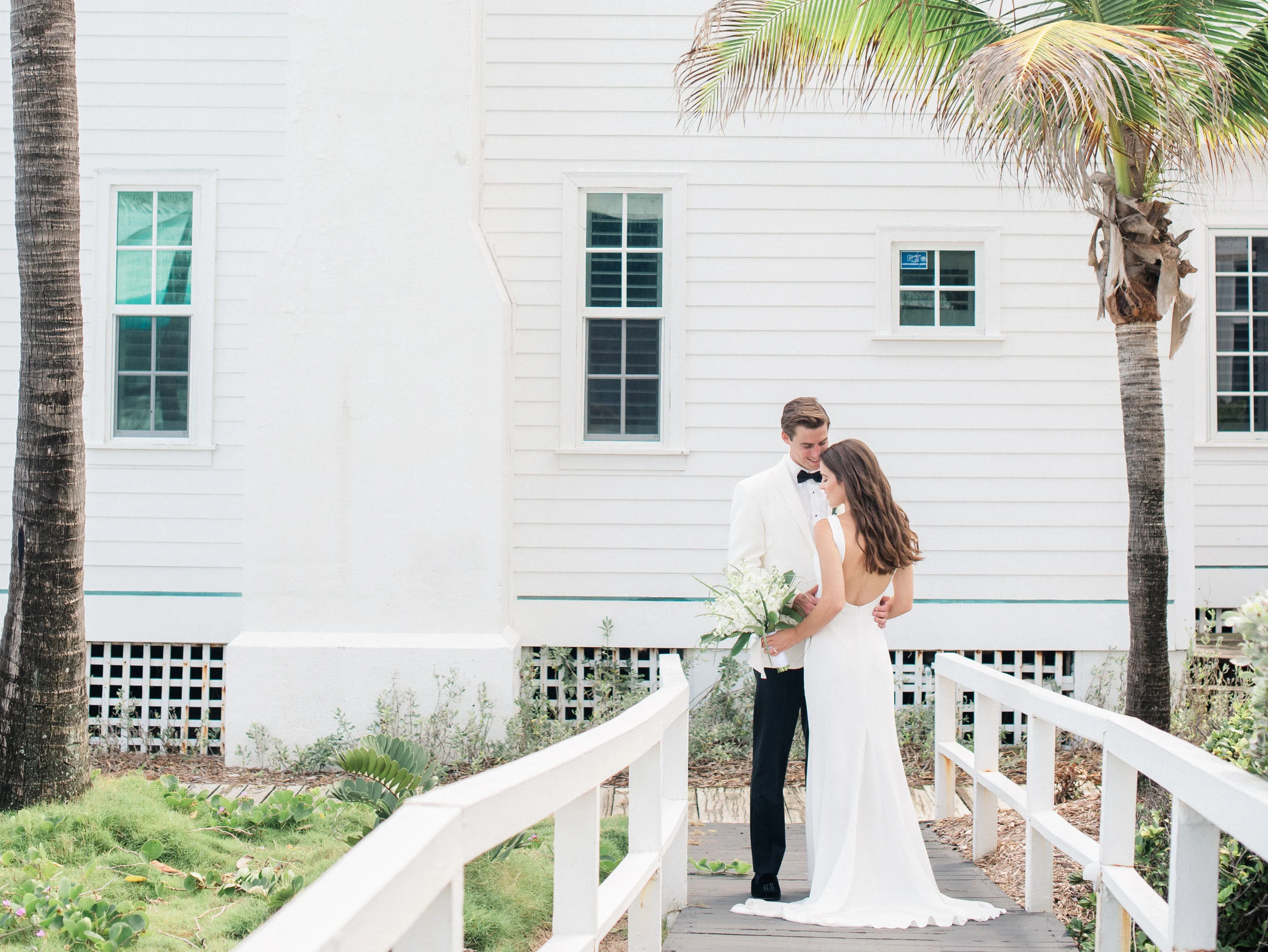 Jess & Kevin were married at the Hillsboro Club in Florida, right down the road from her family home. Since Kevin is from Massachusetts, they loved the "Old Florida meets Martha's Vineyard" aesthetic of the venue. To echo the environment, the couple chose to only use tropical greens, white flora and touches of citrus throughout. With over 15 acres, the oceanfront grounds had everything they could’ve asked for to create an incredible wedding weekend. It felt like one big weekend-long house party, with guests hanging at the beach, drinking at the tiki bar, playing tennis & golf, and having meals together.
