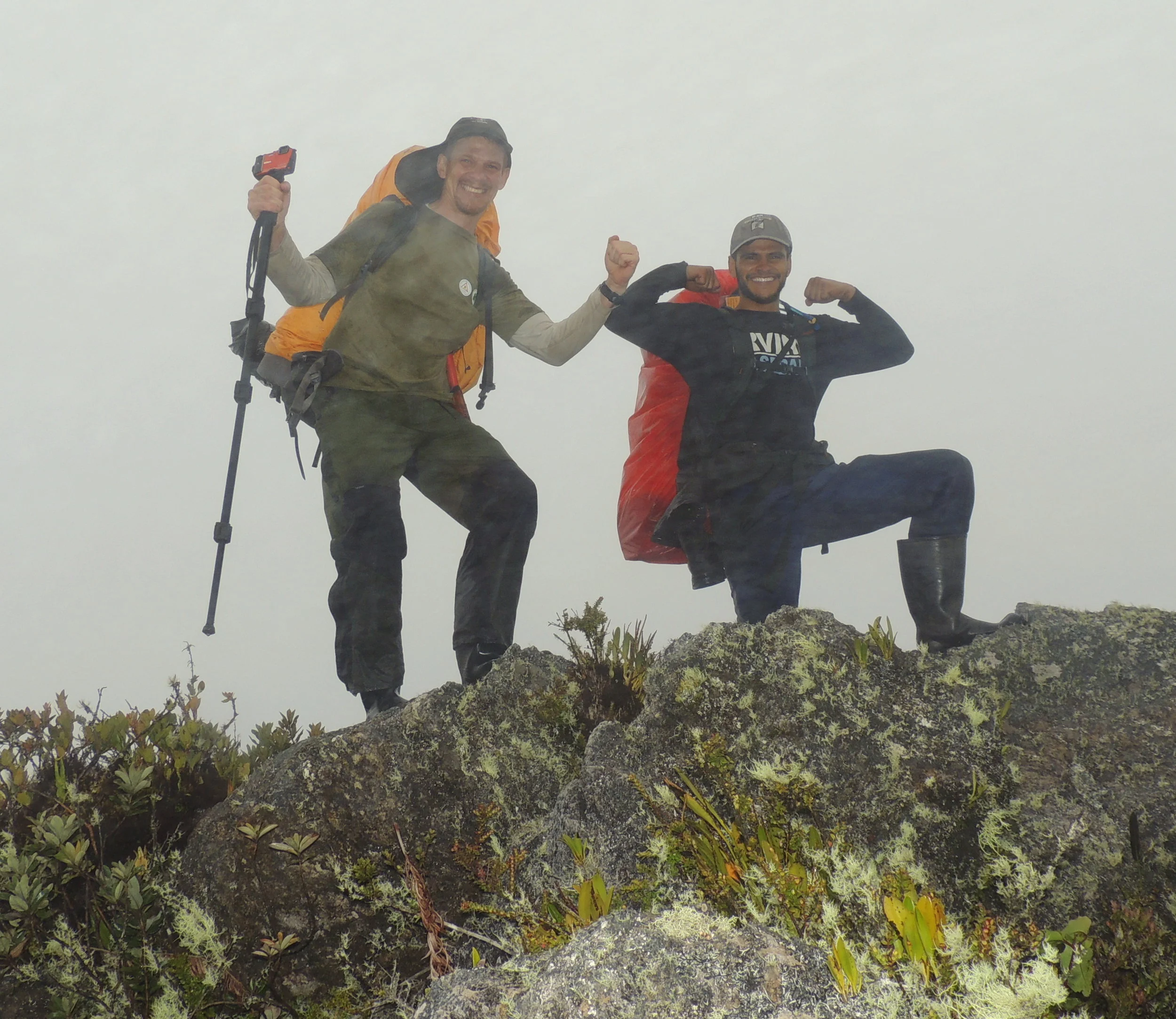 (L-R) Roger Gonzalez and Abner Rodriguez celebrate in the rain and fog as they summit yet another peak on a hard day of hiking.