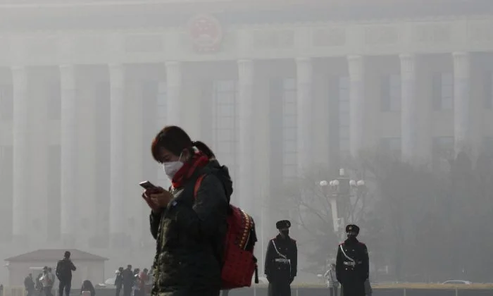 A woman wears a mask for protection against the air pollution on Tiananmen Square in Beijing as the city is blanketed by heavy smog on Jan. 4, 2017. (AP Photo/Andy Wong)