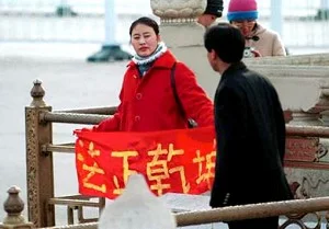 一位法輪功學員在天安門广場展開「法正乾坤」橫幅。