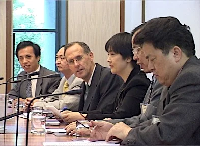 Jennifer addressing a forum inside the Australian Parliament House on March 17, 2005. On the right to her is Bob Brown, former Senator and parliamentary leader of the Australian Greens