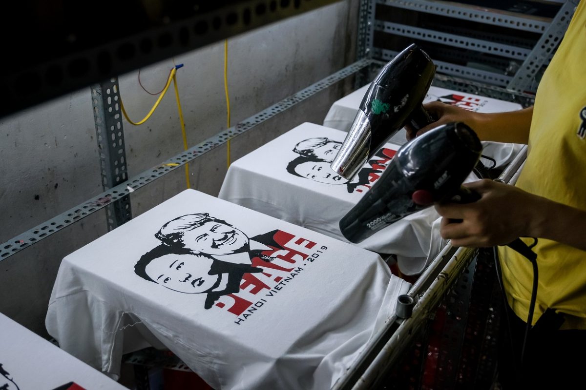 A worker at the t-shirt store of Truong Thanh Duc dry the newly printed t-shirts with the portraits of U.S. President Donald Trump and North Korean leader Kim Jong Un in Hanoi, Vietnam on Feb. 21, 2019. (Linh Pham/Getty Images)