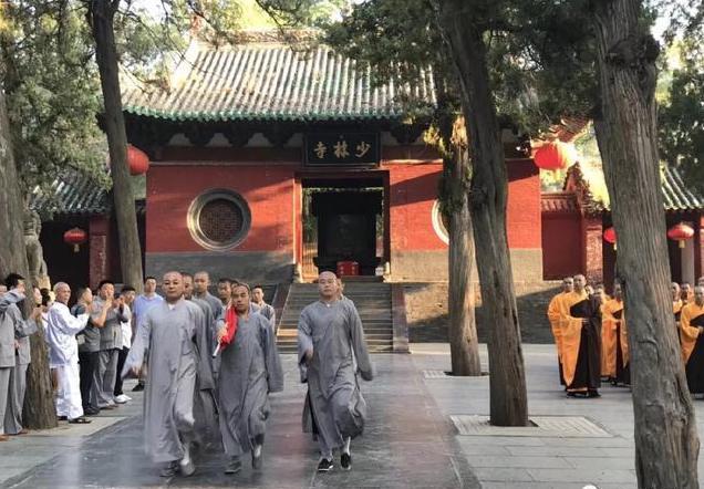 Monks in the famous Shaolin Temple in Henan Province in China march with a Chinese flag during a “Flag Raising Ceremony”. All religious groups in China are required to love the CCP first before they can love or worship their God or Buddhas. 河南少林寺和尚在舉行升旗儀式。在大陸,宗教人士被迫先愛黨,然後才能愛他們的上帝或神佛。