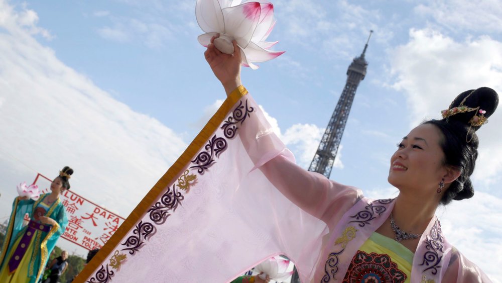 Falun Gong members perform in front of the Eiffel Tower in Paris in a protest against organ harvesting