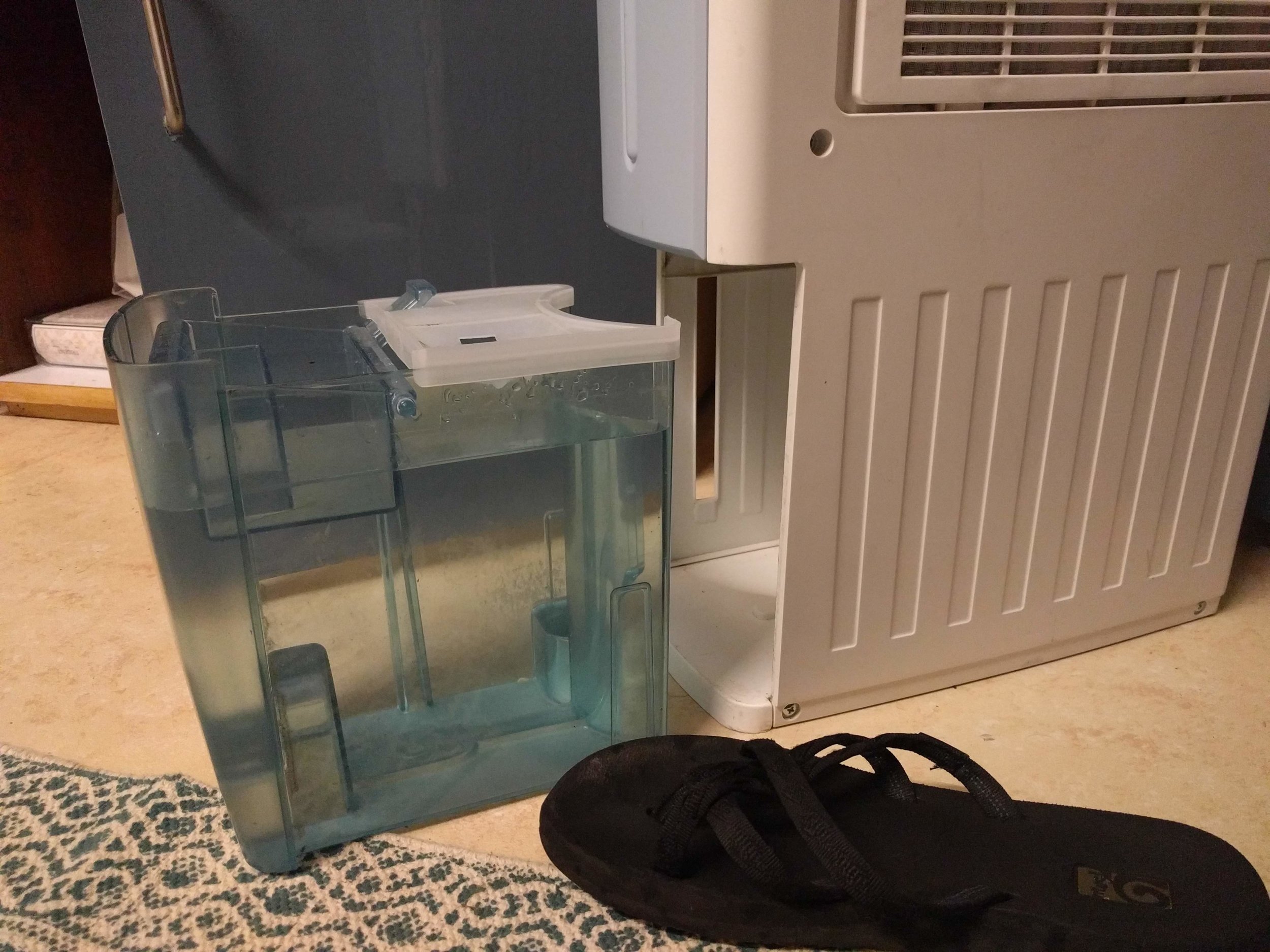 A full dehumidifier tank (flip-flip for scale)