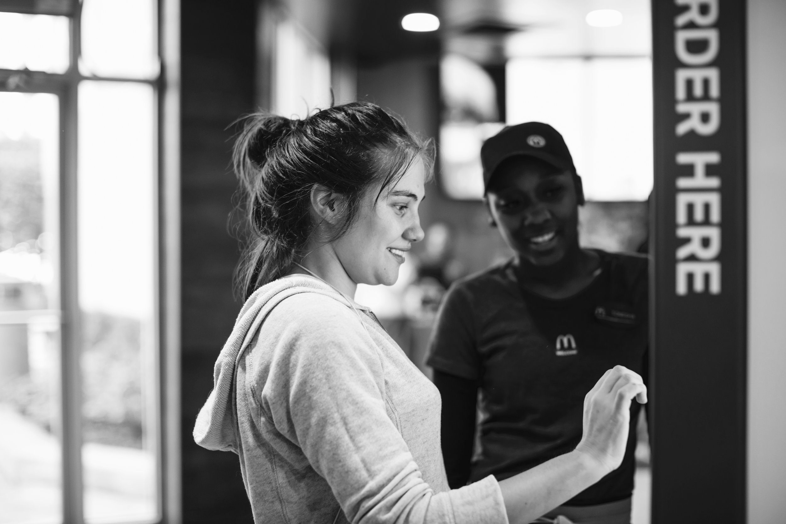 Image source: McDonalds. Customer trying out self serve kiosk at McDonalds