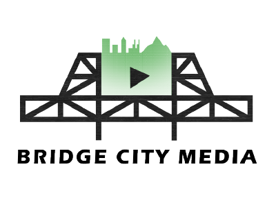 Bridge City Media logo featuring a silhouette of a bridge with a green cityscape and a play button.