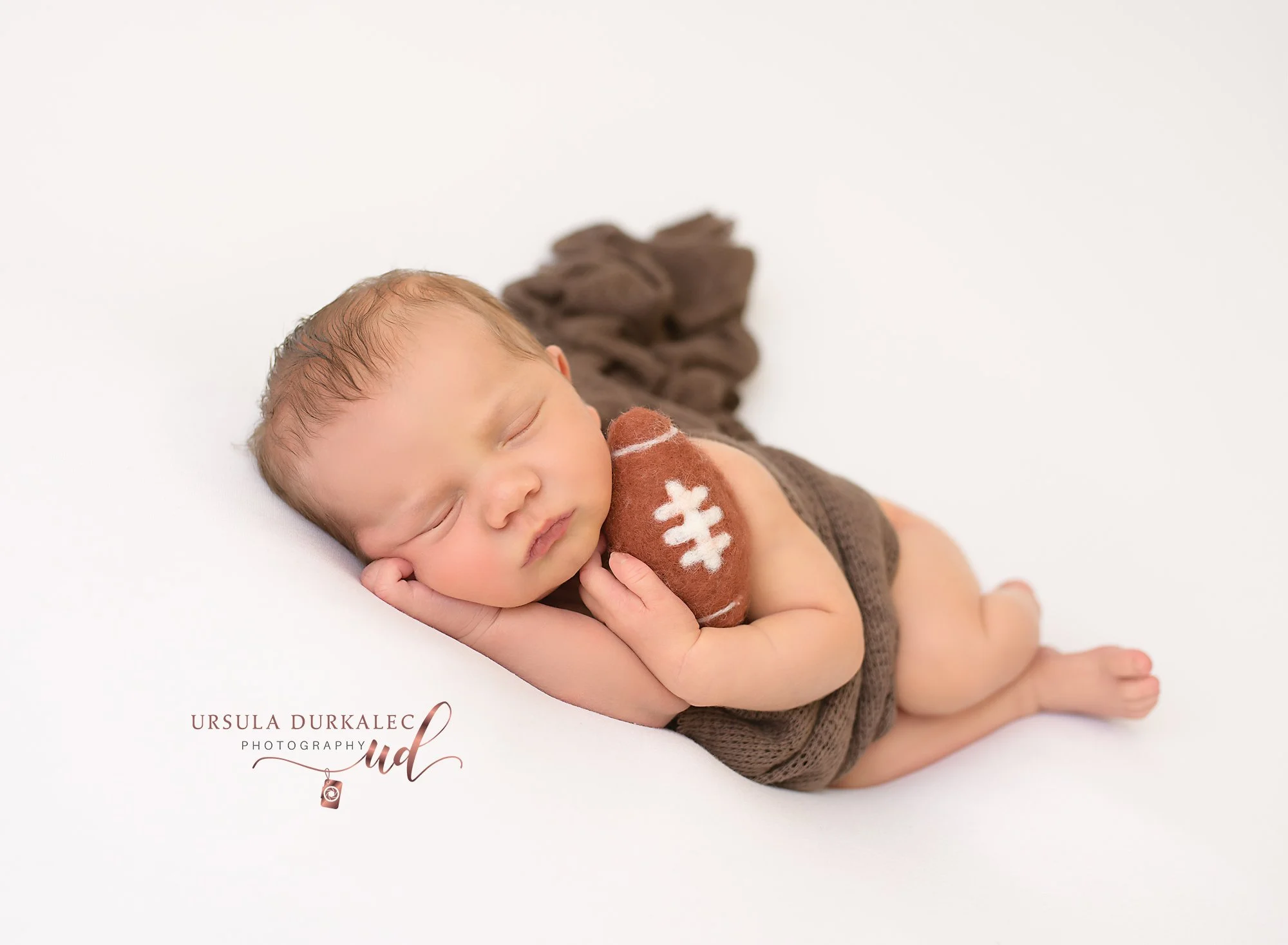 Baby boy with football newborn session U45_2772.jpg