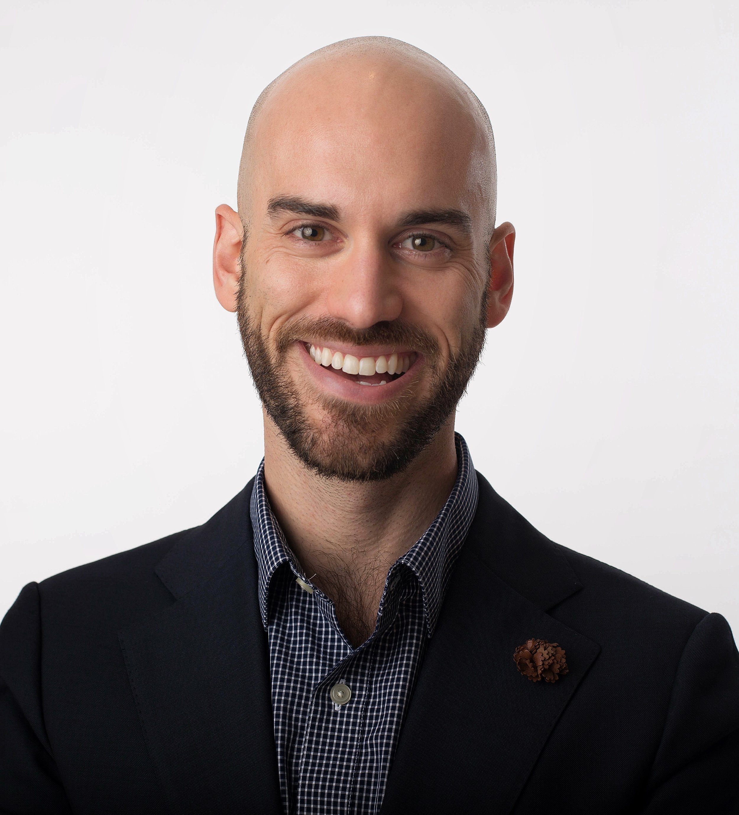 Samuel Yates Headshot (Bald Male, Smiling, in navy shirt and blazer against a white background).jpeg