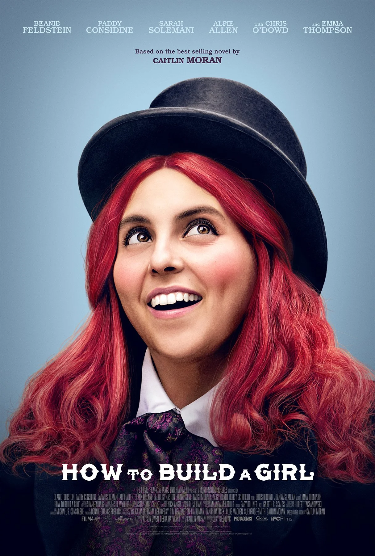 Promotional poster for the movie 'How to Build a Girl' featuring a woman with red hair wearing a black hat, white shirt, and tie, smiling and looking upward.