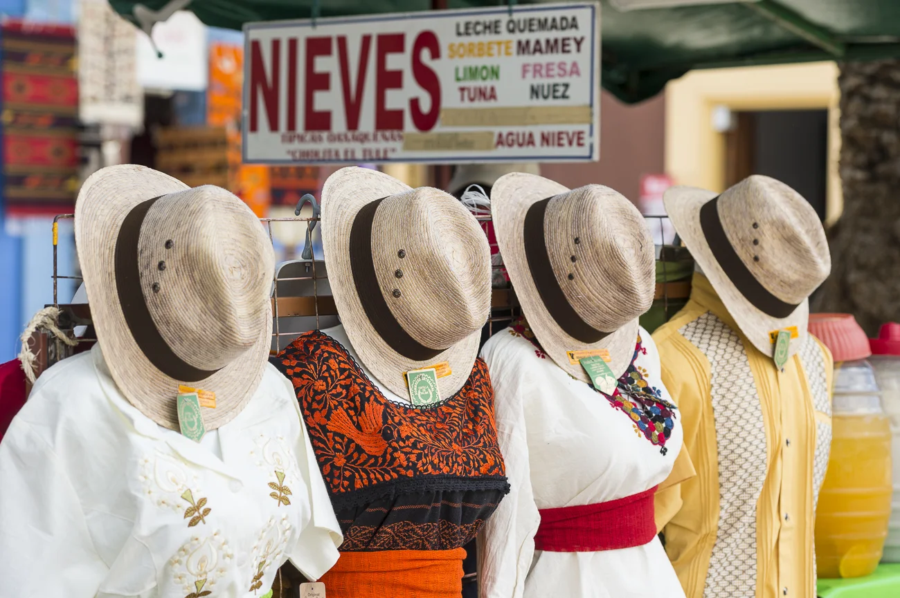 21 En el corazón de la ciudad, junto al Templo de Santo Domingo, encontramos, al fondo los tapetes de Teotitlán, al frente las blusas de diferentes regiones del estado, que sirven demarco para otra tradición oaxaqueña, la deliciosa nieve de garrafa y sus tradicionales sabores.