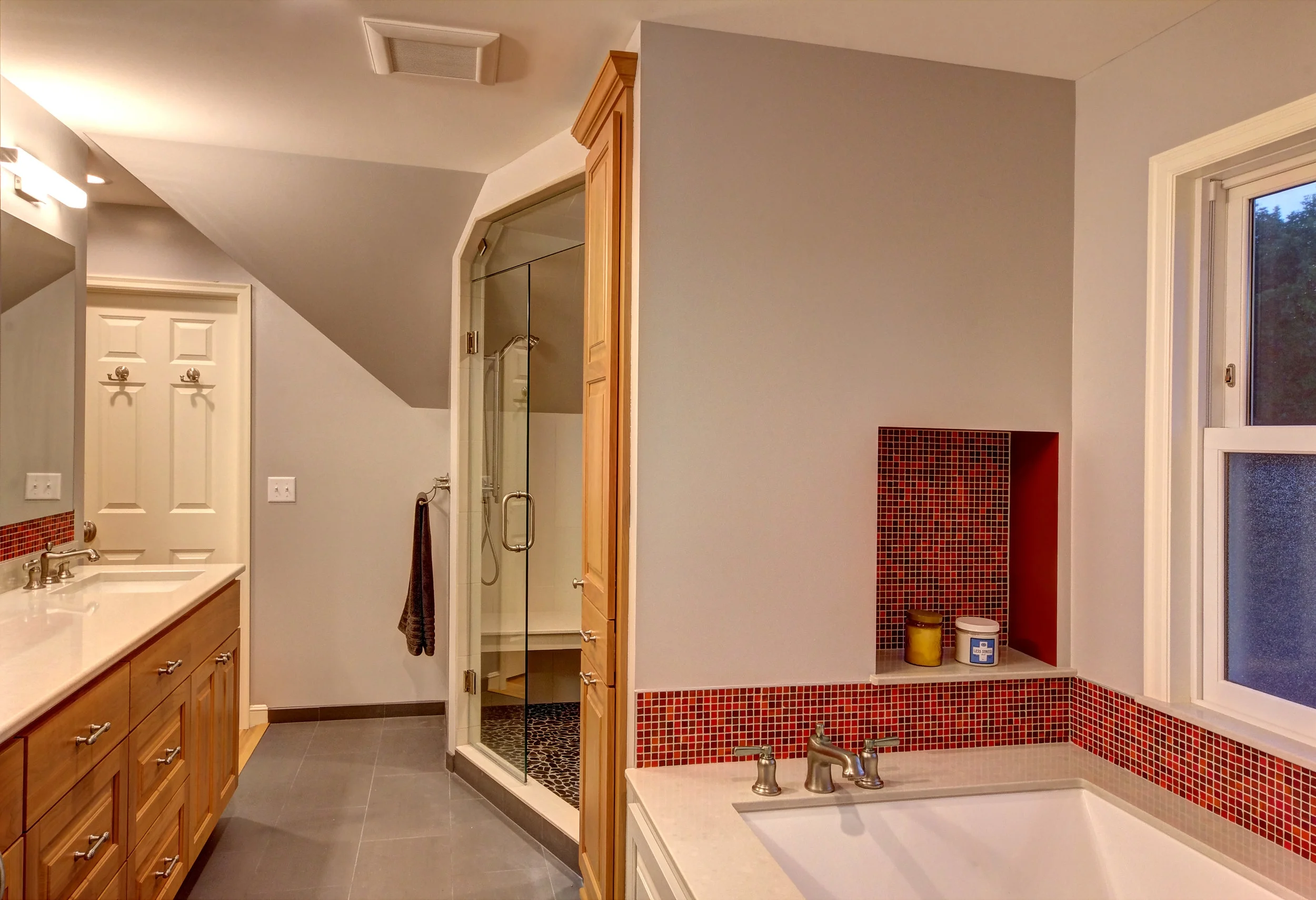 Shower with bench and frameless glass door.