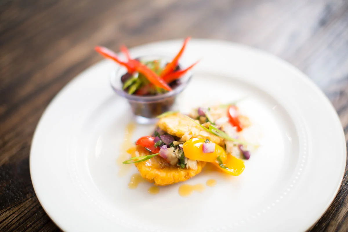 Sauté Codfish over Fried Plantains with black beans tossed in Habanero Vinaigrette