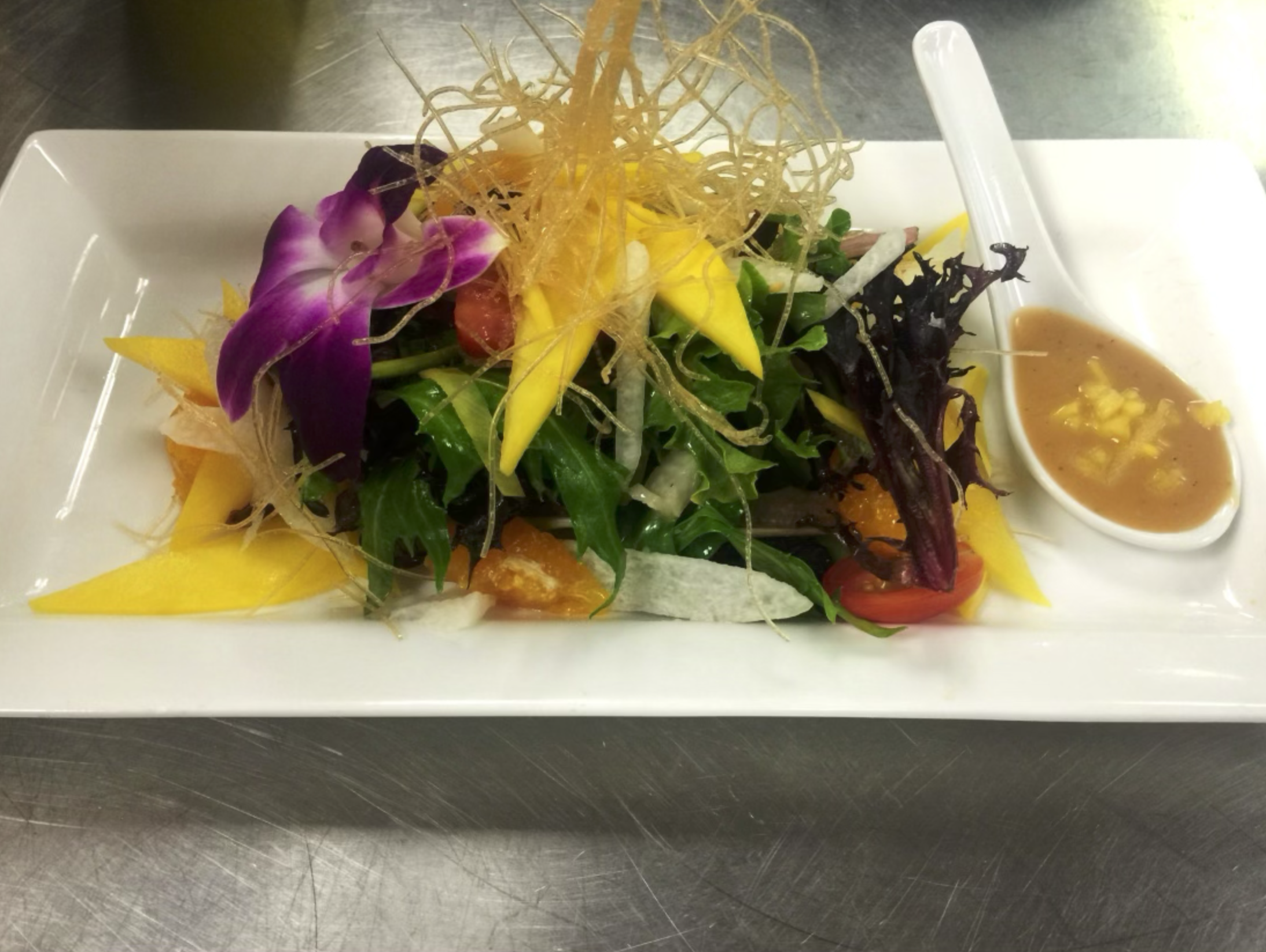 Summer greens topped with sliced mango, crispy noodles and sweet &amp; sour mango vinaigrette 