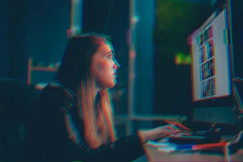 Woman in front of computer reflecting the impact of trauma in the workplace