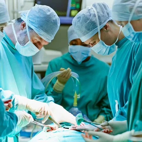Surgeons and medical staff performing a surgery in an operating room.