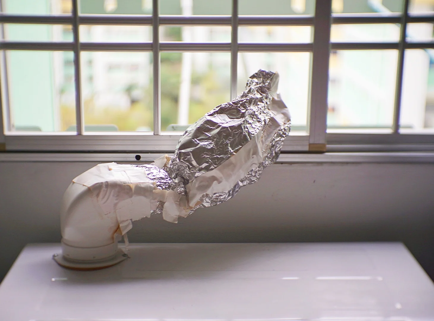 We used aluminium foil to extend the exhaust and vent moist air out the window.