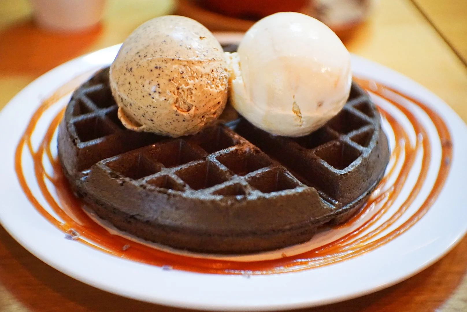 FATCAT charcoal waffles, with Butter Beer ice cream on the left and Butterscotch ice cream on the right. Served with salted caramel sauce and dried lavender garnish.