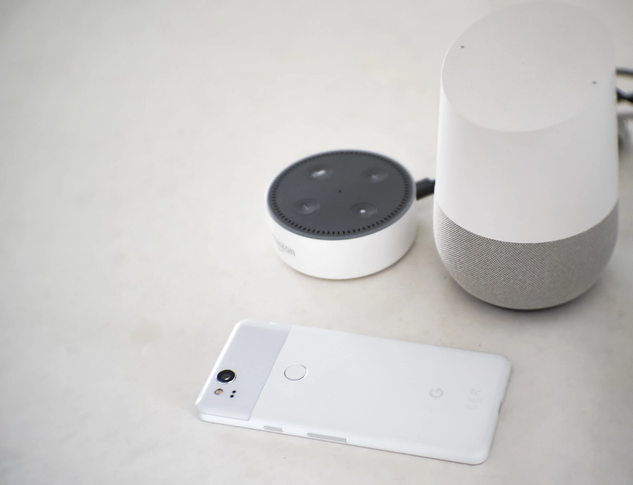 The Google Pixel 2 is smart - just like our Amazon echo dot (to the left) and Google Home (to the right) .