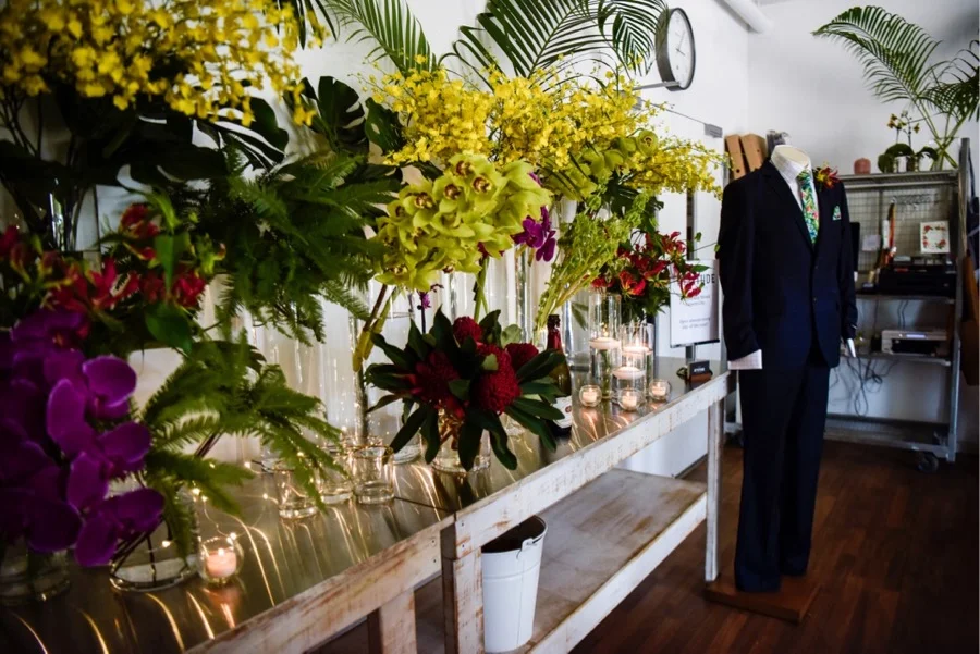 inside Beija Flors Coconut Grove studio, colour popping orchids, interspersed with twinkling candlelight form a stunning tropical backdrop