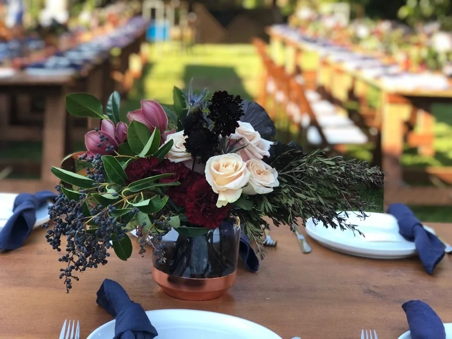 almost black flowers match these copper and smoke glass vases in this floral centrepiece