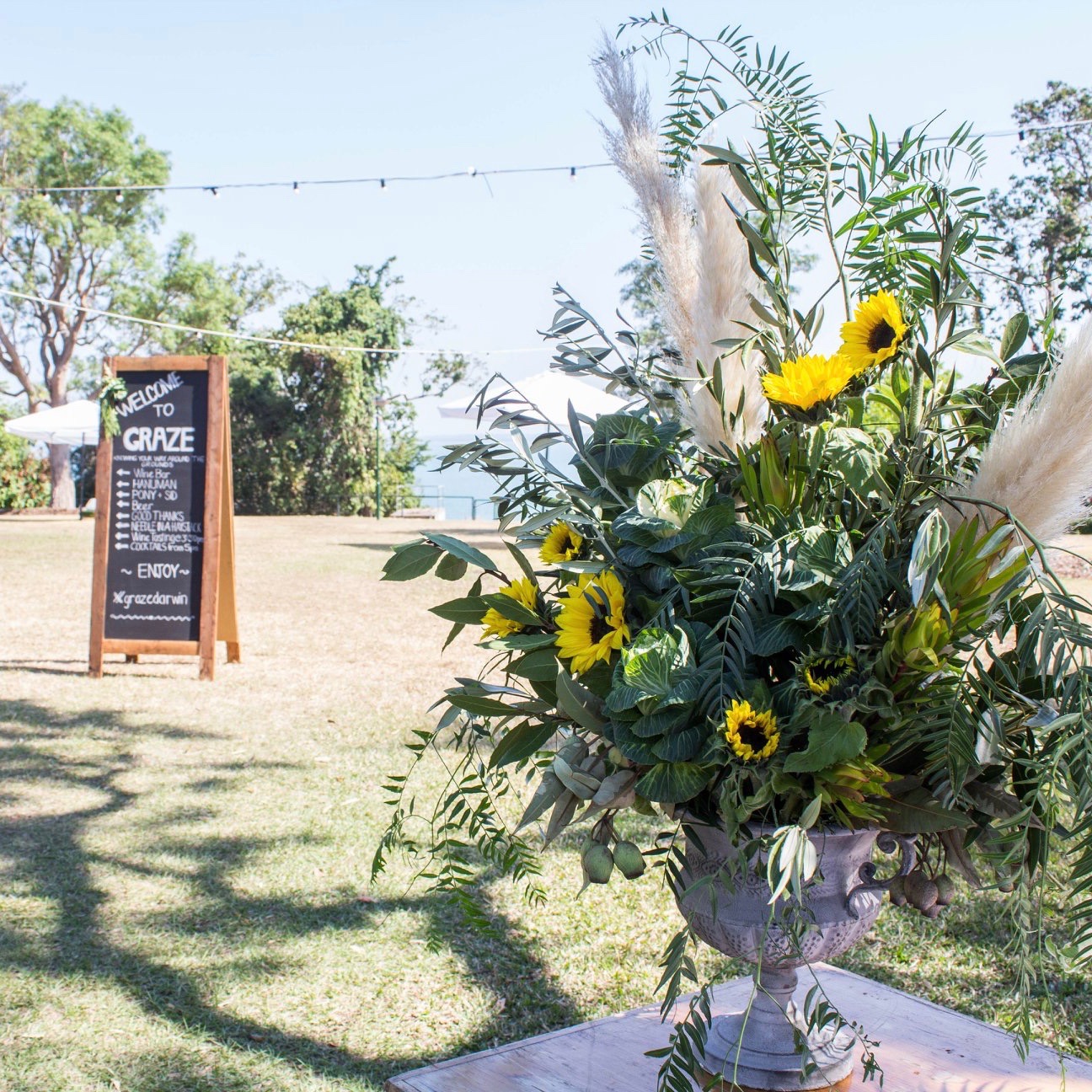 urn floral arrangement of sunflowers, pepper and pampas grass at Graze event in Darwin, NT by Darwin florist, Beija Flor