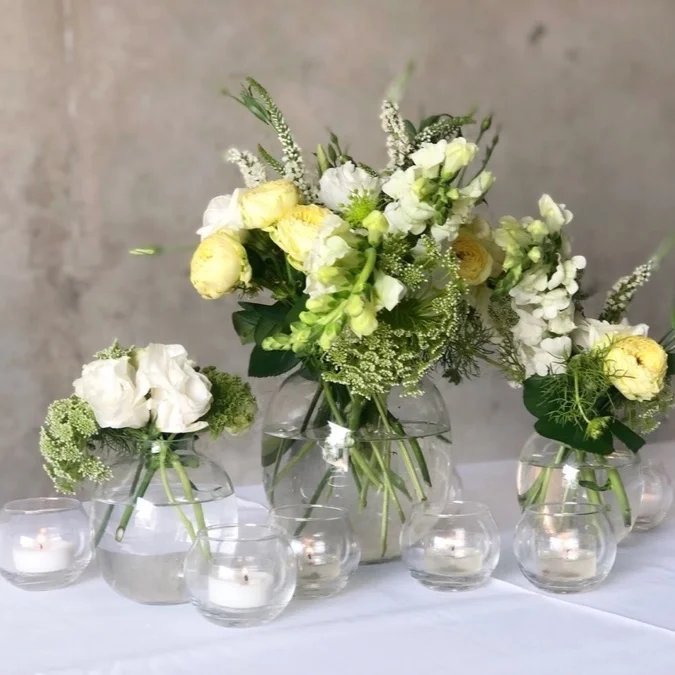 glass vases topped with fresh lemon and white flowers