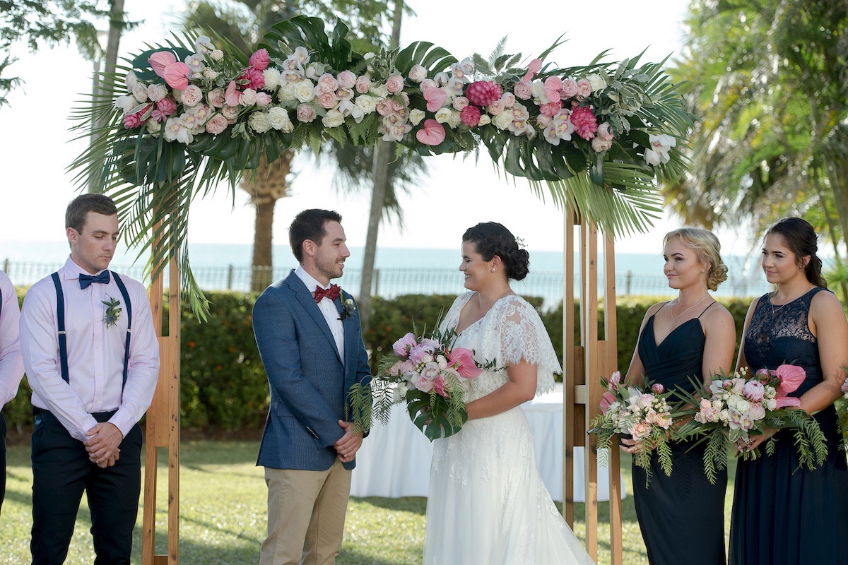 Copy of Wedding party under ceremony arbour clad with palm leaves and pink anthuriums.